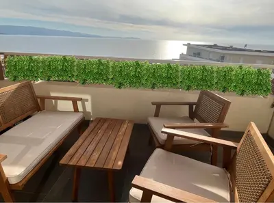 two benches and chairs on a balcony overlooking the ocean at Grand T2 Ajaccio proche Casone in Ajaccio