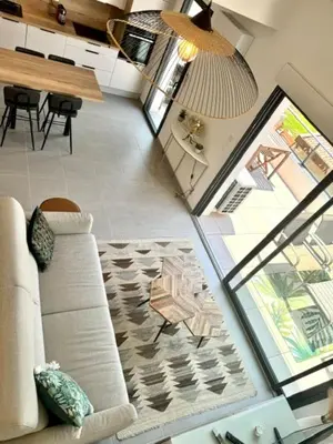 a living room with a couch and a table at Duplex en résidence in Propriano