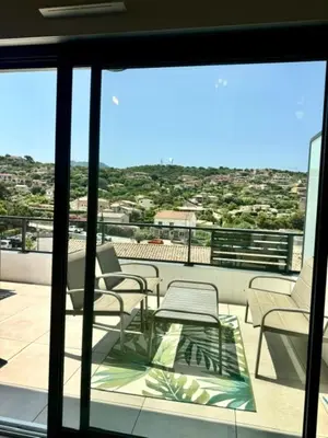 a balcony with chairs and a table and a view at Duplex en résidence in Propriano