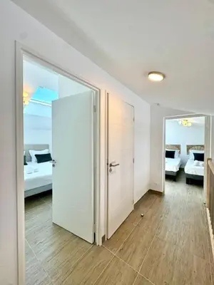 a room with two beds and a hallway with a door at Duplex en résidence in Propriano