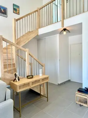 a living room with a staircase and a table at Duplex en résidence in Propriano