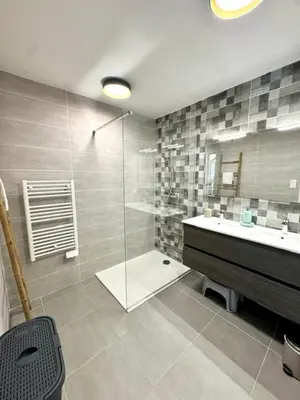 a bathroom with a glass shower and a sink at Duplex en résidence in Propriano