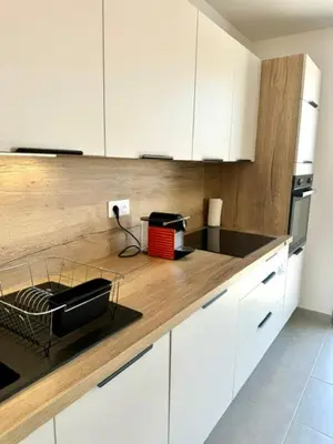a kitchen with white cabinets and a counter top at Duplex en résidence in Propriano