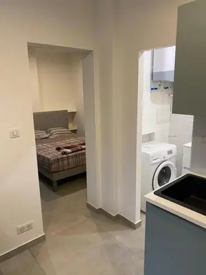 a small kitchen with a bed and a washing machine at Charmant appartement hyper centre in Ajaccio