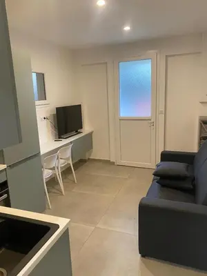 a living room with a couch and a desk with a television at Charmant appartement hyper centre in Ajaccio