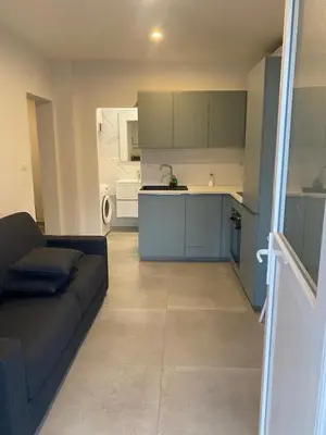 a living room with a couch and a kitchen at Charmant appartement hyper centre in Ajaccio