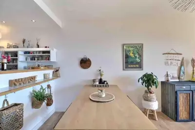a dining room with a wooden table and potted plants at Bel appartement cozy avec magnifique vue mer in Ajaccio