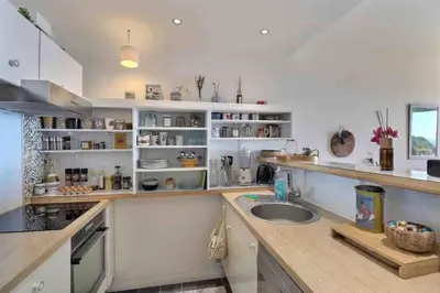 a kitchen with white cabinets and a sink at Bel appartement cozy avec magnifique vue mer in Ajaccio