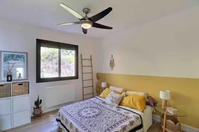 a bedroom with a bed and a ceiling fan at Bel appartement cozy avec magnifique vue mer in Ajaccio
