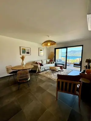 a living room with a couch and a table at Magnifique appart T3 vue mer in Propriano