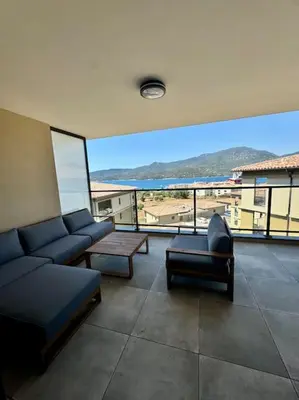 a living room with couches and a view of the ocean at Magnifique appart T3 vue mer in Propriano