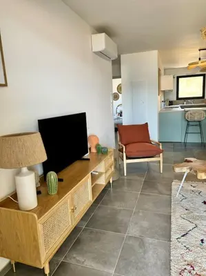a living room with a flat screen tv and a couch at Magnifique appart T3 vue mer in Propriano