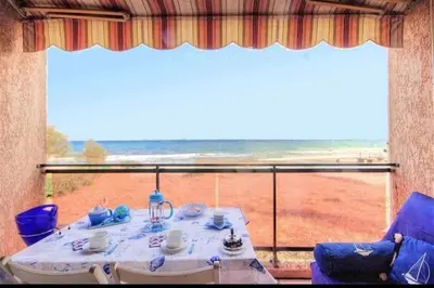 a table and chairs in a room with a large window at Studio les pieds dans l'eau in San-Nicolao