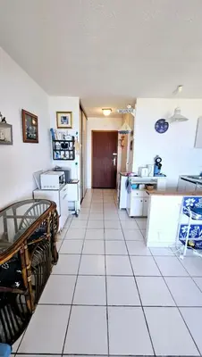 a kitchen with white tiled floors and a hallway at Studio les pieds dans l'eau in San-Nicolao