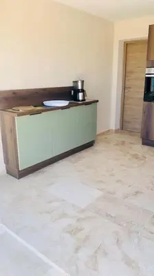 a room with a kitchen with a counter and a door at Villa vue mer et piscine privée in Sari Solenzara