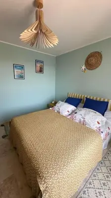 a bedroom with a bed with blue walls and a ceiling at Villa vue mer et piscine privée in Sari Solenzara