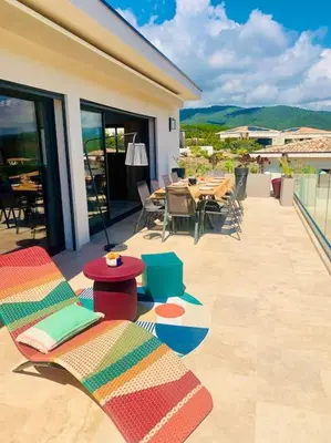 a patio with chairs and tables on a building at Villa vue mer et piscine privée in Sari Solenzara