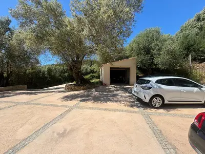 a white car parked in front of a garage at Casa Nostra in Olmeto