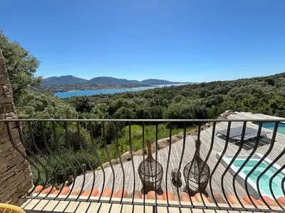 a balcony with a view of a pool and trees at Casa Nostra in Olmeto
