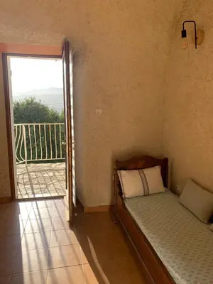 a small bedroom with a bed and a balcony at Maison indépendante Haute-Corse mer et montagne in Santo-Pietro-di-Tenda