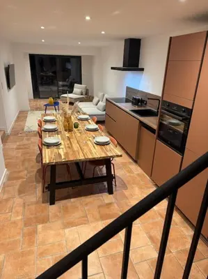 a kitchen with a long wooden table in a room at Spacieux 3 chambres Centre-ville de Porto-Vecchio in Porto-Vecchio