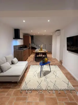 a living room with a white couch and a table at Spacieux 3 chambres Centre-ville de Porto-Vecchio in Porto-Vecchio