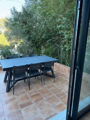 a black picnic table and chairs on a patio at Spacieux 3 chambres Centre-ville de Porto-Vecchio in Porto-Vecchio