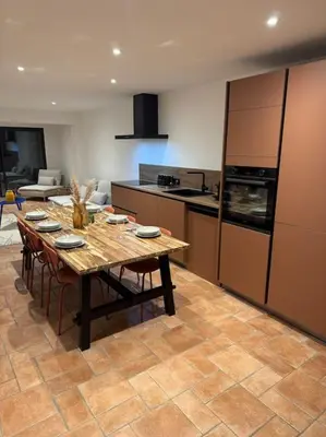 a kitchen with a wooden table with chairs and appliances at Spacieux 3 chambres Centre-ville de Porto-Vecchio in Porto-Vecchio