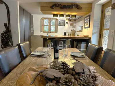 a dining room table with a bottle of wine and glasses at Villa de type bergerie 3 chambres avec piscine in Sotta
