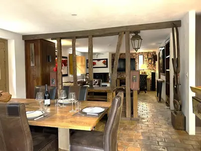 a dining room with a wooden table and chairs at Villa de type bergerie 3 chambres avec piscine in Sotta