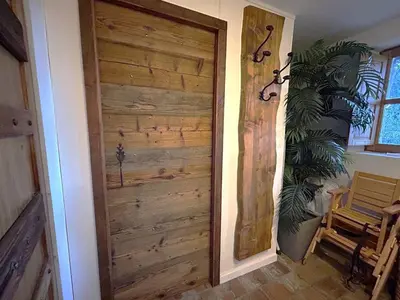 a wooden door in a room with a plant at Villa de type bergerie 3 chambres avec piscine in Sotta