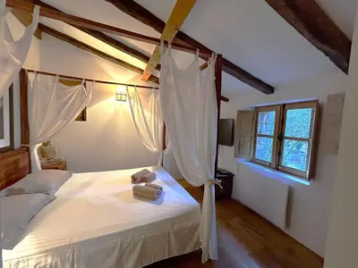a bedroom with a bed with white sheets and a window at Villa de type bergerie 3 chambres avec piscine in Sotta