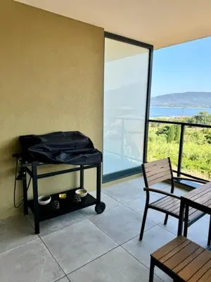 a room with a balcony with a table and a chair at Appart tout équipé et vue sur la mer in Propriano