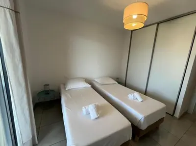 two beds in a small room with a window at Appart tout équipé et vue sur la mer in Propriano