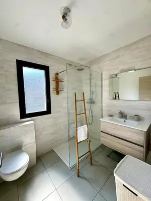 a bathroom with a glass shower and a toilet and a sink at Appart tout équipé et vue sur la mer in Propriano
