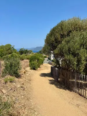 a dirt road with a fence on the side at Appart tout équipé et vue sur la mer in Propriano