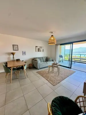 a living room with a couch and a table at Appart tout équipé et vue sur la mer in Propriano