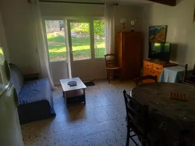 a living room with a bed and a table at Maisonnette in Albertacce