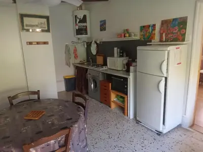 a kitchen with a table and a white refrigerator at Maisonnette in Albertacce