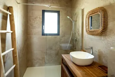 a bathroom with a sink and a glass shower at Villa 3 chambres avec piscine privative in Porto-Vecchio