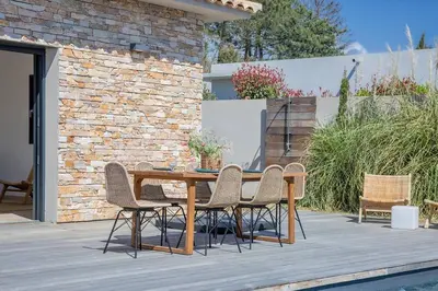 a wooden table and chairs on a patio at Villa 3 chambres avec piscine privative in Porto-Vecchio