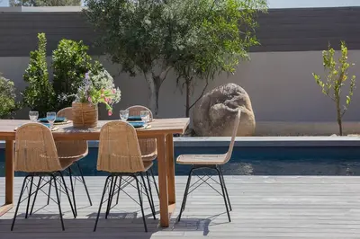 a wooden table with three chairs and a table with drinks on it at Villa 3 chambres avec piscine privative in Porto-Vecchio
