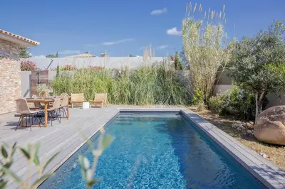 a pool in a backyard with a table and chairs at Villa 3 chambres avec piscine privative in Porto-Vecchio