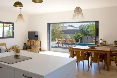 a kitchen and dining room with a table and chairs at Villa 3 chambres avec piscine privative in Porto-Vecchio