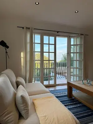 a living room with a white couch and a sliding glass door at Spacieux 2 chambres Centre-ville de Porto-Vecchio in Porto-Vecchio