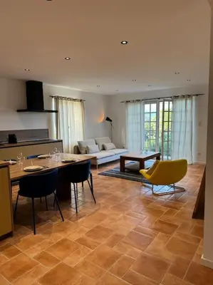 a kitchen and living room with a table and chairs at Spacieux 2 chambres Centre-ville de Porto-Vecchio in Porto-Vecchio