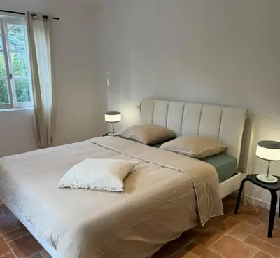 a large white bed with two pillows and two lamps at Spacieux 2 chambres Centre-ville de Porto-Vecchio in Porto-Vecchio