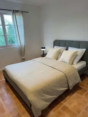 a large bed in a bedroom with a window at Spacieux 2 chambres Centre-ville de Porto-Vecchio in Porto-Vecchio