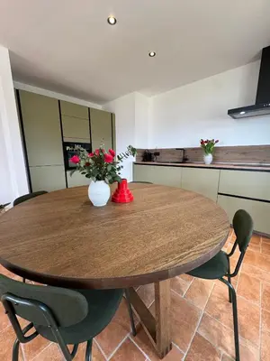 a wooden table with chairs and a vase of flowers on it at Spacieux et lumineux 2 chambres vue mer Centre-ville de Porto-Vecchio in Porto-Vecchio