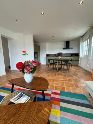 a living room with a vase of flowers on a table at Spacieux et lumineux 2 chambres vue mer Centre-ville de Porto-Vecchio in Porto-Vecchio